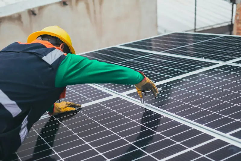 Operario instalando placas solares en Galicia